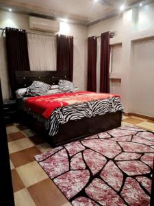 sypialnia z łóżkiem z czerwonym kocem i dywanem w obiekcie شارع مدينه منوره w Kairze
