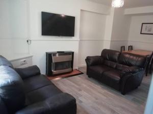 a living room with a couch and a flat screen tv at Haverfordwest terraced home in Pembrokeshire