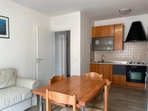 a living room with a wooden table and a kitchen at Bardolino Lake Apartments in Bardolino