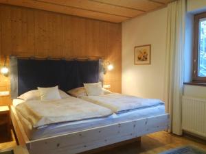 1 dormitorio con 1 cama grande y cabecero negro en Apartment Schmiderer, en Landeck