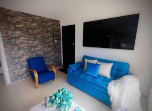 a living room with a blue couch and a chair at Descanso y confort in La Tebaida