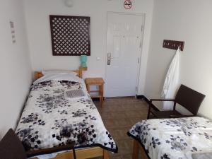 a bedroom with two beds and a table and a door at TRIO sobe in Jajce
