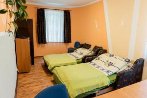 a room with two beds and a table and chairs at Pokoje Gościnne u Markusa in Polanica-Zdrój