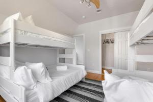 a white bedroom with two bunk beds and a rug at Amazing family-friendly and group-friendly accommodation #TheBackDorch in Boston