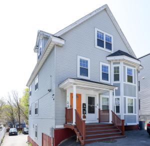 a white house with a porch and a staircase at Amazing family-friendly and group-friendly accommodation #TheBackDorch in Boston