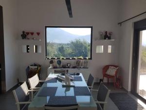 jadalnia ze stołem i krzesłami oraz oknem w obiekcie Villa Marina w mieście Dhrámia
