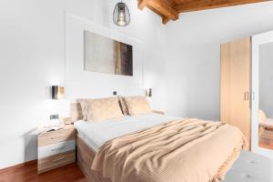 ein weißes Schlafzimmer mit einem Bett und einem Nachttisch in der Unterkunft The Village in Novigrad Istria