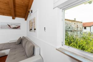 ein Wohnzimmer mit einem Sofa und einem großen Fenster in der Unterkunft The Village in Novigrad Istria