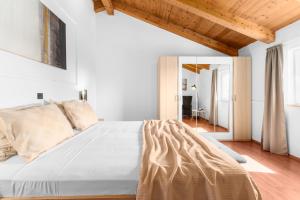 sypialnia z dużym łóżkiem i drewnianym sufitem w obiekcie The Village w mieście Novigrad