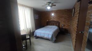 um quarto com uma cama e uma parede de tijolos em Hotel Esperanza em Lima