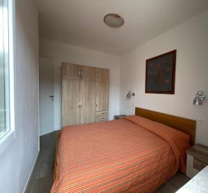 a bedroom with a bed with an orange bedspread at Bardolino Lake Apartments in Bardolino
