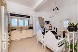 a hospital room with white chairs and a table at Queen of Santorini in Karterados