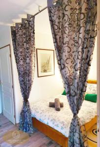 um quarto com uma cama com cortinas em Magnifique appartement 2 pièces em Deauville