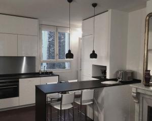 kuchnia z białymi szafkami i czarnym blatem w obiekcie Air conditioning Paris central stylish apartment w Paryżu