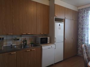 cocina con nevera blanca y fregadero en Двухкомнатные просторные апартаменты. en Imatra