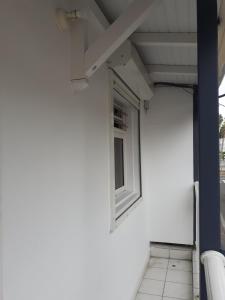a window on the side of a white building at DUPLEX HIBISCUS in Les Abymes
