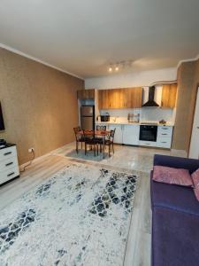 ein Wohnzimmer mit Tisch und Küche in der Unterkunft 2 комнатная Нурсат ЖК Алтын Шанырак in Schymkent