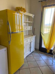 a yellow refrigerator in a kitchen with a window at Casa di Rebecca in Murta Maria