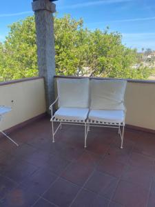 a white bench sitting on a balcony with a view at Casa di Rebecca in Murta Maria