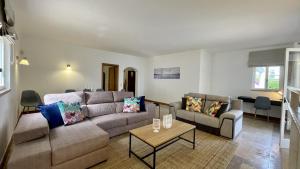 een woonkamer met een bank en een tafel bij Solar by Check-in Portugal in Albufeira