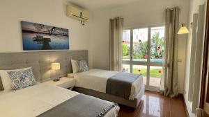 een slaapkamer met twee bedden en een raam bij Solar by Check-in Portugal in Albufeira +24 foto's
