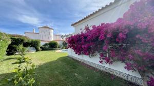 een hek met paarse bloemen aan de zijkant van een gebouw bij Solar by Check-in Portugal in Albufeira