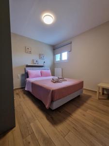 a bedroom with a large bed with pink pillows at CASA DI NIMA in Ioannina