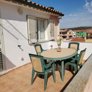 patio ze stołem i krzesłami na balkonie w obiekcie La casa di Alessia w mieście Santa Teresa Gallura