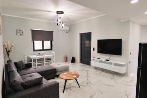 a living room with a couch and a flat screen tv at Iphigenia Luxury Flat in Sarandë