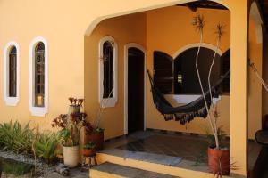 a porch of a house with a hammock on it at Hospedaria Bem Te Vi Arraial d'Ajuda in Arraial d'Ajuda