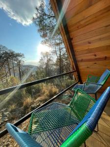three chairs on a porch with a view of the mountains at Portocielo Cabin in La Marquesa