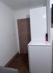 um frigorífico branco num quarto com uma porta em N 25 em Horley