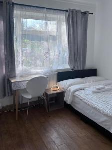 1 dormitorio con cama, escritorio y ventana en N 25 en Horley