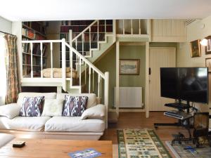 a living room with a white couch and a tv at Red Squirrel Haven in Hawes