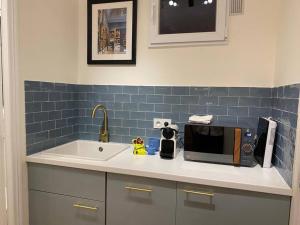 a kitchen counter with a microwave and a sink at Cosy studio a 20 min del Arco del Triunfo en RER in Maisons-Laffitte