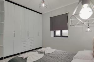 a bedroom with white walls and a bed with two pillows at Iphigenia Luxury Flat in Sarandë +76 photos