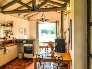 a kitchen with a table and a dining room at Casa de campo - retiro con encanto en las sierras in Minas