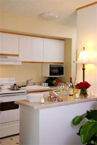 a kitchen with white cabinets and a counter top at Jockey Club Suites in Las Vegas