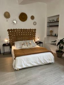 Schlafzimmer mit einem großen Bett mit einem Kopfteil aus Holz in der Unterkunft L'Auberge Espagnole - Bed & Breakfast in Apt