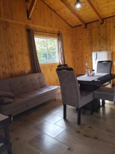 um quarto com um sofá, uma mesa e uma janela em Cabana Azinheira em Urubici
