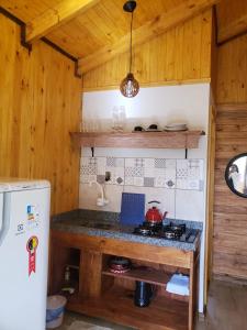 a kitchen with a stove and a counter top at Cabana Azinheira in Urubici