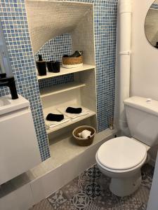La salle de bains est pourvue de toilettes et d'un mur carrelé bleu. dans l'établissement L'Auberge Espagnole - Bed & Breakfast, à Apt