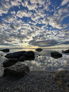 a cloudy sky with rocks in the water at Athina Studios in Chorto