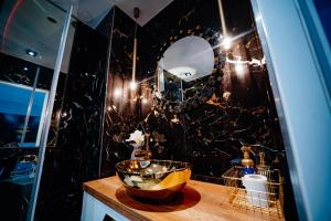 un baño con espejo y un bol en una encimera en Apartament Pod Skrzydłami Aniola, en Bytom