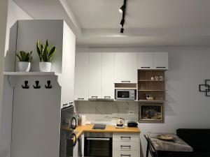 a kitchen with white cabinets and a wooden counter top at Comfy Nest Apartment- free parking in Tirana