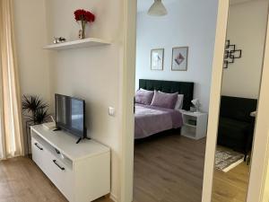 a bedroom with a bed and a television on a dresser at Comfy Nest Apartment- free parking in Tirana