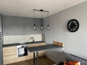 a kitchen with a counter and a clock on the wall at Zamkowa in Sanok