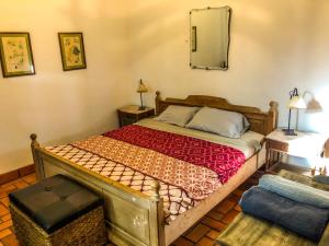 1 dormitorio con 1 cama con espejo en la pared en Casa de campo - retiro con encanto en las sierras en Minas