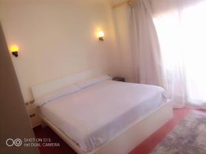 a white bed in a small room with a window at Villa Oussama porto families only in Ain Sokhna