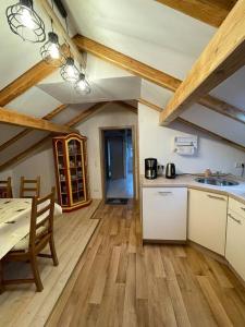 a kitchen with wooden floors and a table and a room at Ferienwohnung Aussicht, Monheimer Alb, Altmühltal 